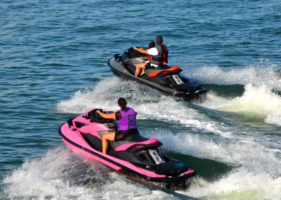 Two jet skis with man woman and child