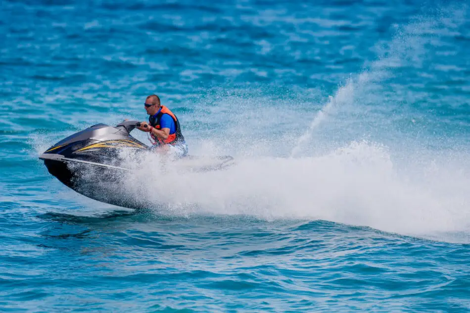 Driving a jet ski in the water with the spray