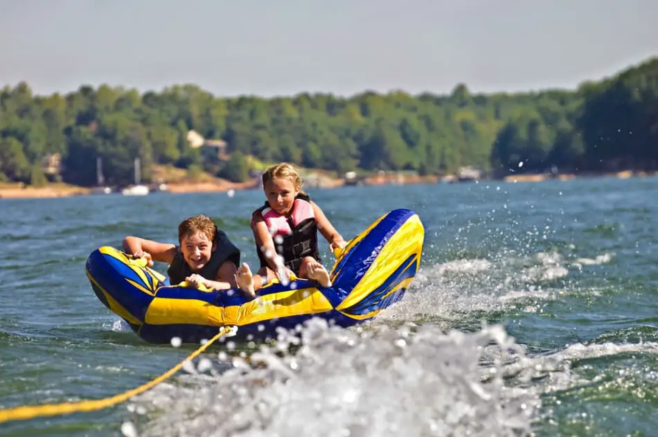 Two kids tubing on the lake